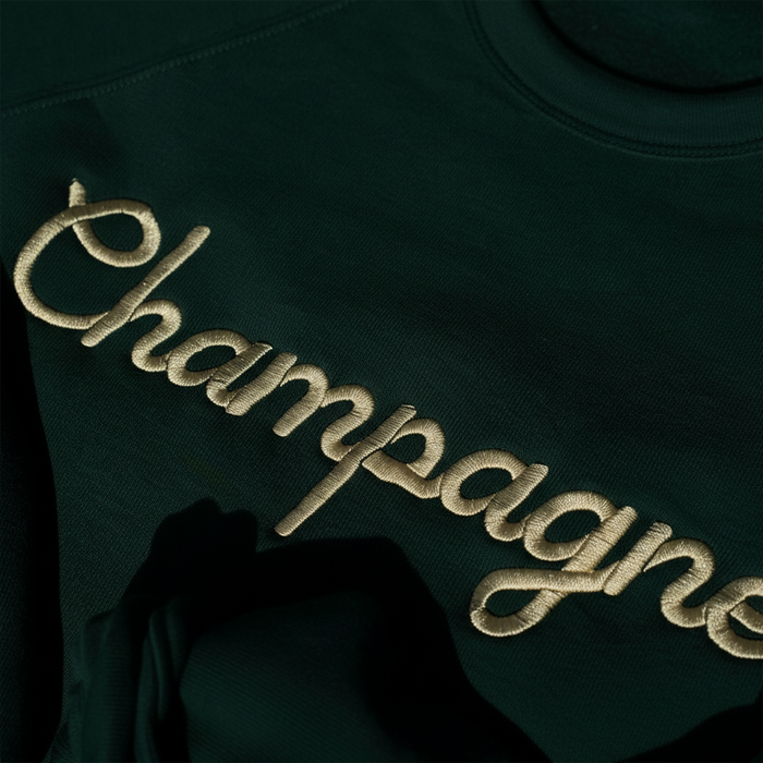 Close-up of champagne embroidery detail on crewneck sweatshirt