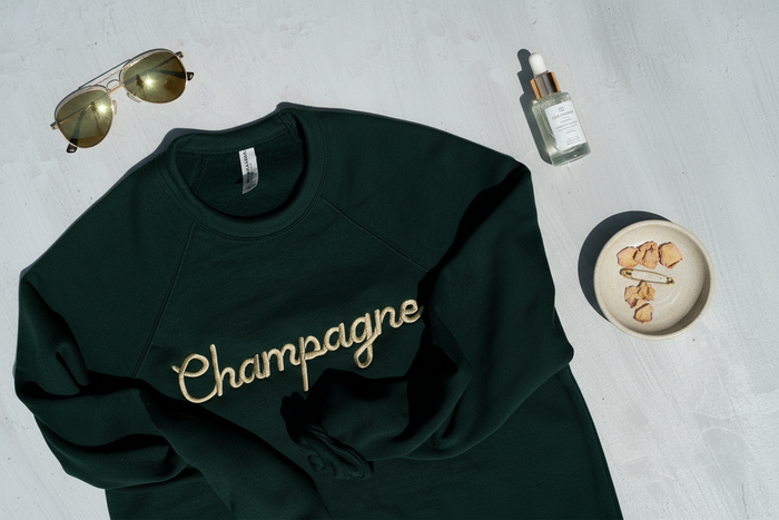 Flat lay of Champagne Embroidered Crewneck Sweatshirt styled on a clean surface