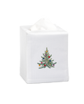 A white tissue cover with a green christmas tree with glittery ornaments in the center.