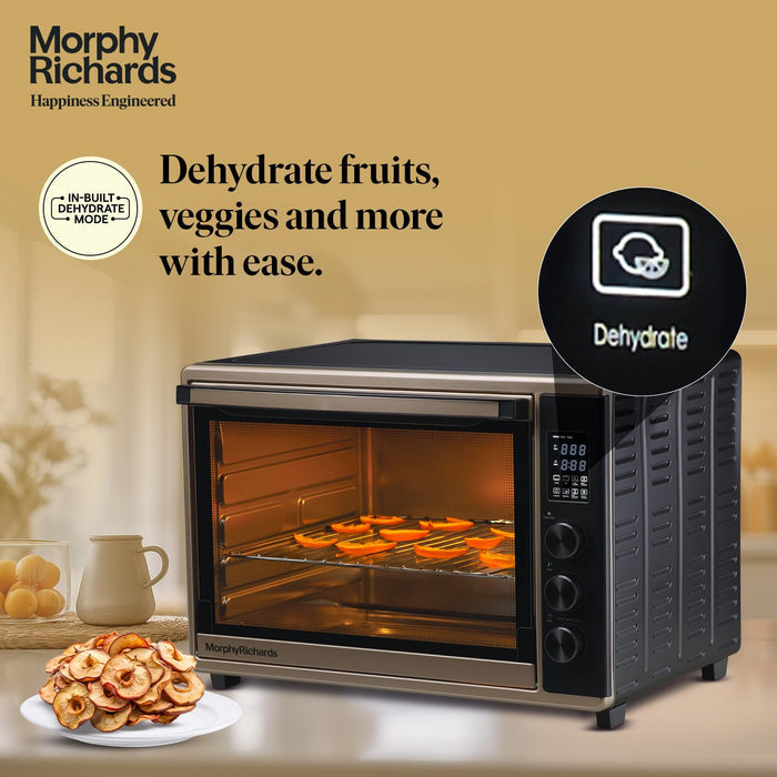 Morphy Richards 52L Digital OTG Champagne Gold and Black showing included accessories - bake pan, grill tray, and rotisserie fork set on wooden countertop